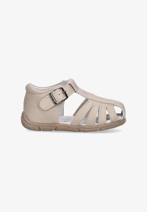 Sandal de cuero beige claro con lados abiertos, cierre de hebilla y suela de goma flexible. Presenta cortes horizontales para una mayor transpirabilidad.