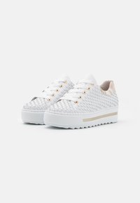 White platform sneakers with woven texture, gold eyelets, and a subtle gold accent on the sole. Rubber sole with zigzag pattern for traction.