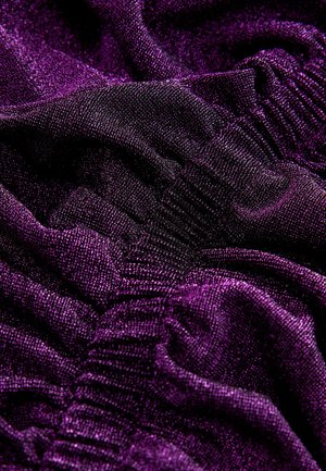 Vibranta purpura auduma ar mirdzošu tekstūru, kurā ir maigi izsisti salocījumi un ribota kakla līnija. Bagātīgi krāsots un gluds virsmu.