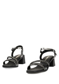 Sandalias negras de tacón cuadrado con múltiples tiras texturizadas, adornadas con detalles brillantes, correa en el tobillo y una suela suave.