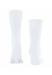Weiße kniehohe Socken aus weichem Stoff, mit gerippten Bündchen, glatter Textur und einem kleinen gedruckten Etikett an der Unterseite.