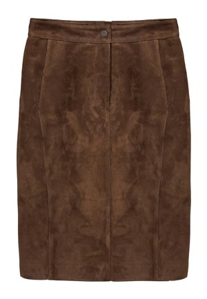 Kvinde står iført en beige bluse med lange ærmer, brun ruskindnederdel til knæet, sorte strømpebukser og sorte knæhøje støvler på en hvid baggrund.