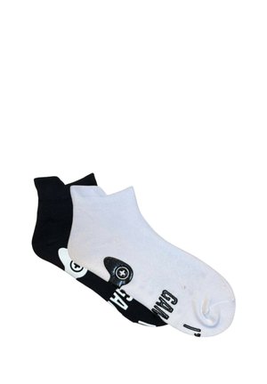 Calcetines cortos en blanco y negro que presentan diseños contrastantes. El calcetín negro tiene un logo blanco, mientras que el calcetín blanco muestra texto y gráficos en negro.