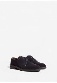 Chaussures oxford en daim noir avec un bout arrondi, des lacets bleu contrastés et un design texturé sur les côtés. Semelles en caoutchouc plates pour le confort.