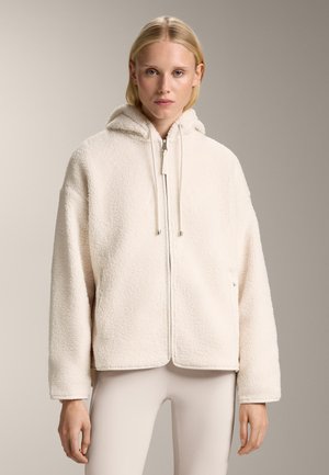 Crème-kleurige fleece jacket met een rits aan de voorkant, een oversized capuchon en trekkoorden. Beschikt over een zachte, gestructureerde oppervlakte en zijzakken.
