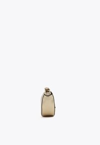 Una borsa elegante beige con una tracolla dorata, vista di lato, appoggiata su uno sfondo bianco semplice.