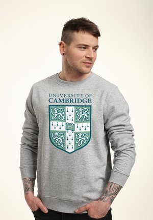 Grauer Sweatshirt mit dem Emblem der University of Cambridge in Grün und Weiß. Aus Baumwollmaterial, Rundhalsausschnitt, langen Ärmeln und gerippten Bündchen.