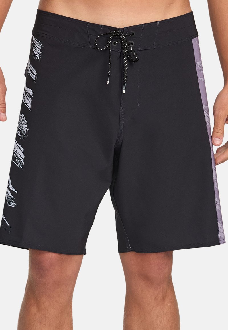 Pantaloni da bagno neri realizzati in materiale leggero, con un pannello laterale viola e motivi grafici in bianco, dotati di una vita con cordoncino.