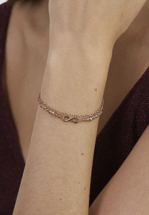 Rose gold bracelet with an infinity symbol; double chain design adorned with small beads. Smooth texture, elegant and simple style.