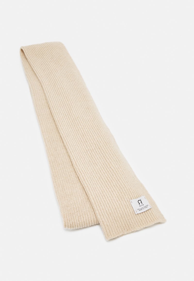 Écharpe en laine côtelée de couleur crème, pliée, avec une petite étiquette blanche affichant le logo de la marque et du texte à une extrémité.