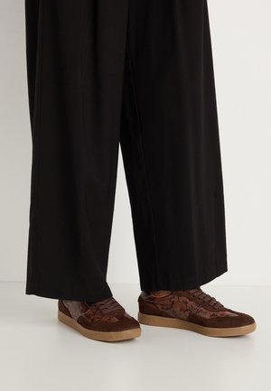 Brązowe sneakersy z mieszanym materiałem, zawierającym zamszowe i wężowe akcenty, okrągły nos, sznurowane zapięcie oraz teksturowane gumowe podeszwy.