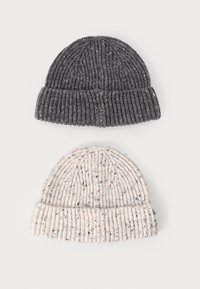 Dos gorros de punto: uno gris oscuro con una textura acanalada y sutiles motas, y otro beige claro con detalles similares. Ambos tienen bordes doblados.