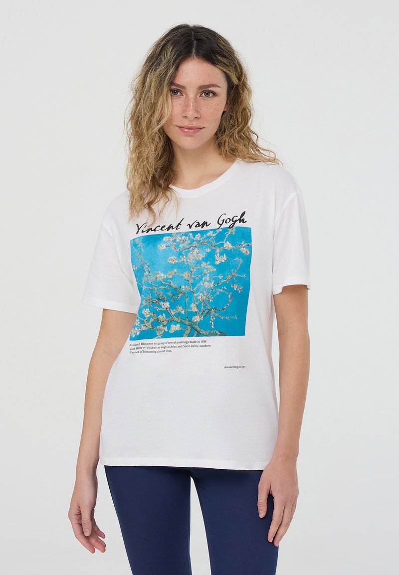 T-shirt in cotone bianco con una stampa quadrata blu con un design floreale e la scritta "Vincent van Gogh." Maniche corte e vestibilità rilassata.