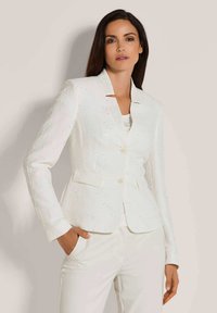 Witte textuur blazer met een reverskraag, twee voorzakken en twee knopen. Draag het over een lichte top en combineer het met witte broeken.