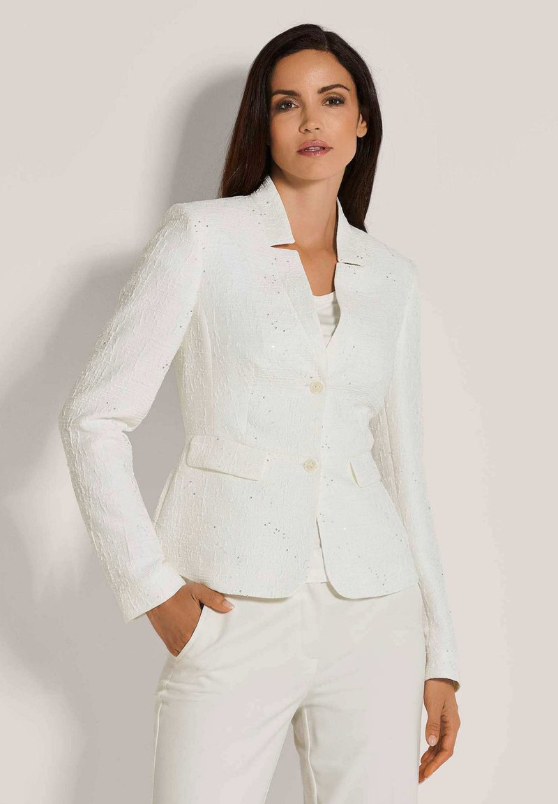 Witte textuur blazer met een reverskraag, twee voorzakken en twee knopen. Draag het over een lichte top en combineer het met witte broeken.