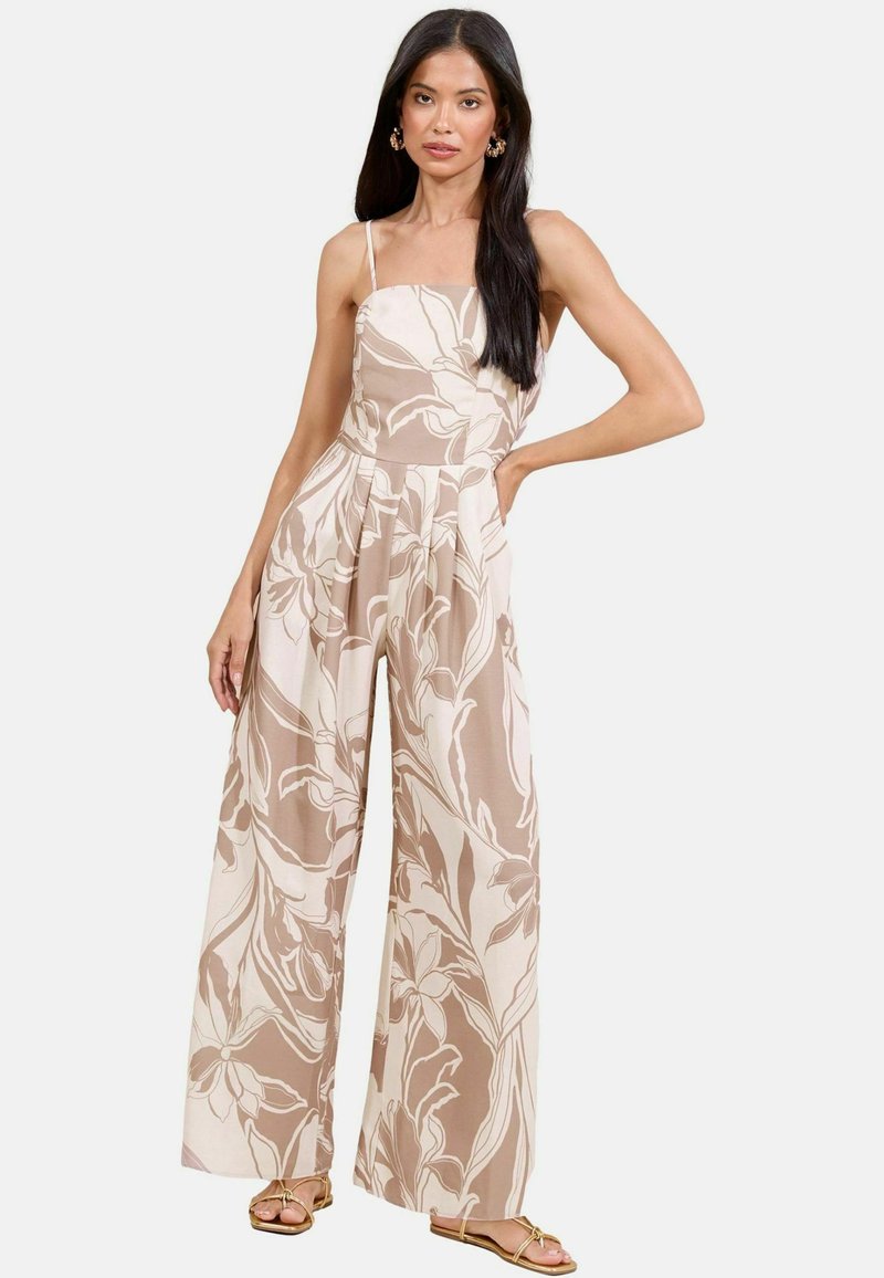 Jumpsuit floreale beige e crema, con gambe ampie, scollatura quadrata e spalline sottili, realizzato in un tessuto leggero con una texture liscia.
