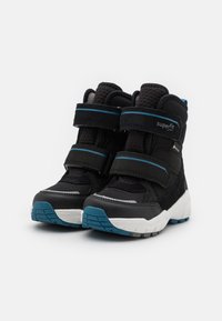 Černé vysoké boty s modrými akcenty a dvěma suchými zipy. Vyrobené z texturované tkaniny a syntetických materiálů; mají bílou a modrou podrážku.