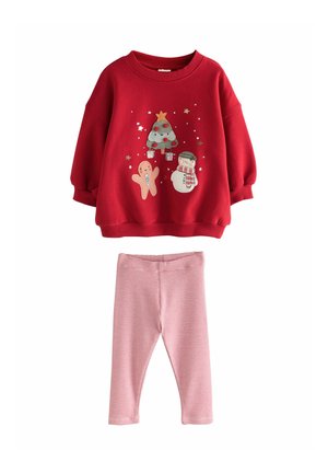 Red sweatshirt with festive graphics including a Christmas tree, gingerbread, and snowman; paired with pink striped leggings.