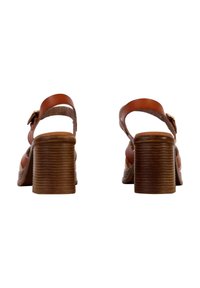 Braune Leder-Absatzsandalen mit breiten Knö strapsen und einer Schnalle. Texturierte, runde Blockabsätze mit horizontalen Rillen. Offenes Zehendesign.