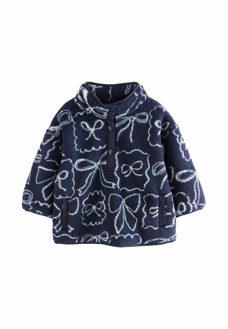 Pulover din fleece bleumarin cu modele de fundițe albe, guler înalt, închidere frontală cu nasturi și buzunare laterale. Textură moale și croială lejeră.