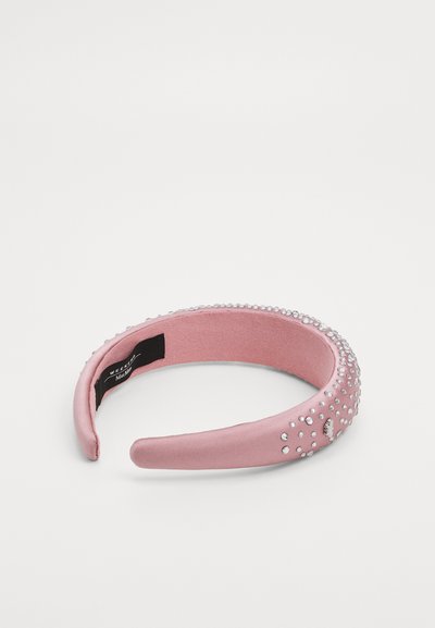 Rozā satīna galvassega ar gludu tekstūru, kuras ārējā malā ir izkaisīti caurspīdīgi rhinestones. Iekšējā oderējums ir izgatavots no mīkstas auduma.