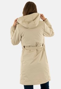 Giacca lunga beige realizzata in tessuto resistente all'acqua, dotata di cappuccio, coulisse, vita con cintura e polsini elastici. Tessuto morbido e design semplice.