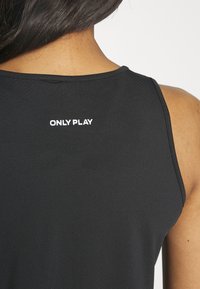 Top atletico nero con scollatura rotonda, senza maniche, e logo bianco "ONLY PLAY" sul retro del collo. Tessuto morbido e con una consistenza particolare.