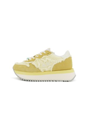 Sneaker in suede e tessuto di colore giallo chiaro con bordi sfrangiati, dettagli bianchi e una suola testurizzata con un motivo di battistrada pronunciato.