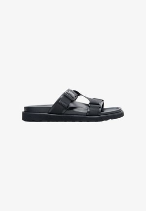 Black sandal featuring a flat sole, fabric straps, and a simple design. The straps are adjustable with a buckle for a secure fit.
