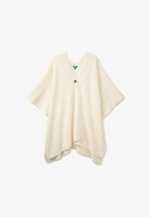 Crèmekleurige kabelgebreide poncho met V-hals en enkele bruine knoopsluiting aan de voorkant, afgebeeld op een witte achtergrond.