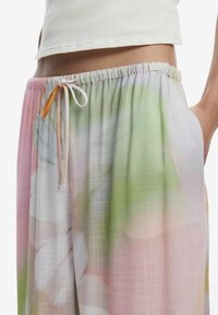 Pantaloni con stampa floreale multicolore, dotati di cintura elastica con cordoncino, tessuto leggero e vestibilità comoda.
