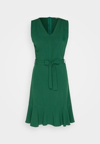 Robe sans manches vert émeraude avec un col en V, une ceinture nouée à la taille et un ourlet à volants évasé, présentée sur un fond blanc uni.