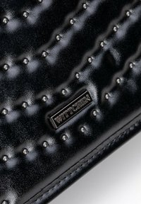 Borsa in vernice nera con texture trapuntata e borchie arrotondate, con targhetta del logo in argento. Finitura liscia che ne valorizza l'aspetto visivo.