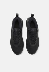 Sorte Nike-sko med mesh-overdel, rund tå, snørelukning, polstret krave og gummisål. Minimal branding i matchende farve.