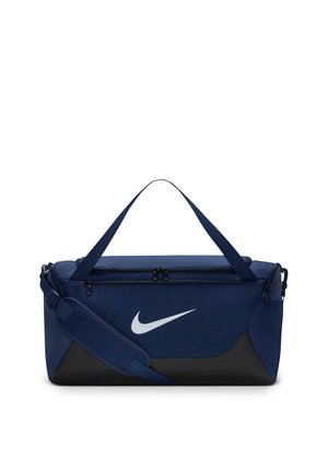 Sac de sport Nike bleu marine et noir avec deux compartiments à fermeture éclair, bandoulière réglable et poignées de transport sur fond blanc.