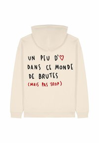 Krem pulover s kapuco z rdeče-črnim francoskim besedilom »Un peu d'amour dans ce monde de brutes (mais pas trop)« in rdečo ikono srca.