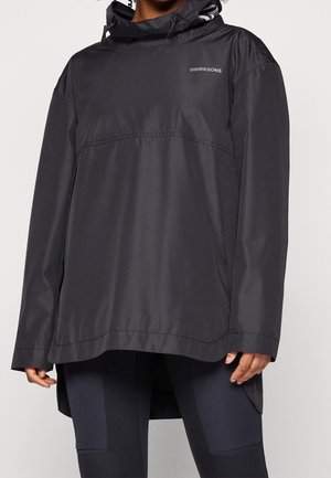 Person wearing a black Didriksons hooded rain jacket with long sleeves and black leggings against a plain background.