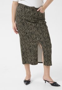 Khaki midi sukňa s čiernym tigrovým prúžkom, so bočným rozparkom a vreckami, doplnená čiernymi lodičkami s špicatou špičkou.
