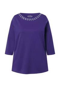 Violetti pitkähihaine pusero, jossa on pyöreä kaulus ja valkoisia koristeellisia neliökuvioita kaulan lähellä.