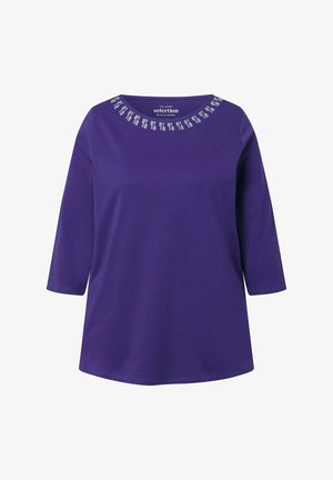 Paarse blouse met lange mouwen en ronde halslijn, voorzien van een decoratief vierkant patroon in het wit nabij de kraag.