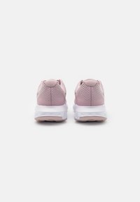 Scarpe da ginnastica rosa con tomaia in mesh testurizzato, colletto imbottito e suola bianca ammortizzata. Presentano un design minimalista e un tallone rinforzato.