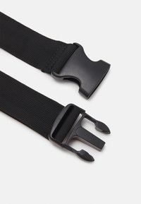 Fekete nylon heveder, műanyag csattal, duplán kioldható mechanizmussal. A heveder texturált felülettel rendelkezik a tapadás és tartósság érdekében.