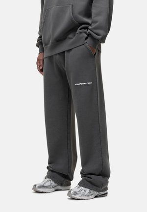 Gray sweatshirt and sweatpants made from soft fabric, featuring a loose fit, side pockets, and "GOODFORNOTHING" printed in white on the pants.