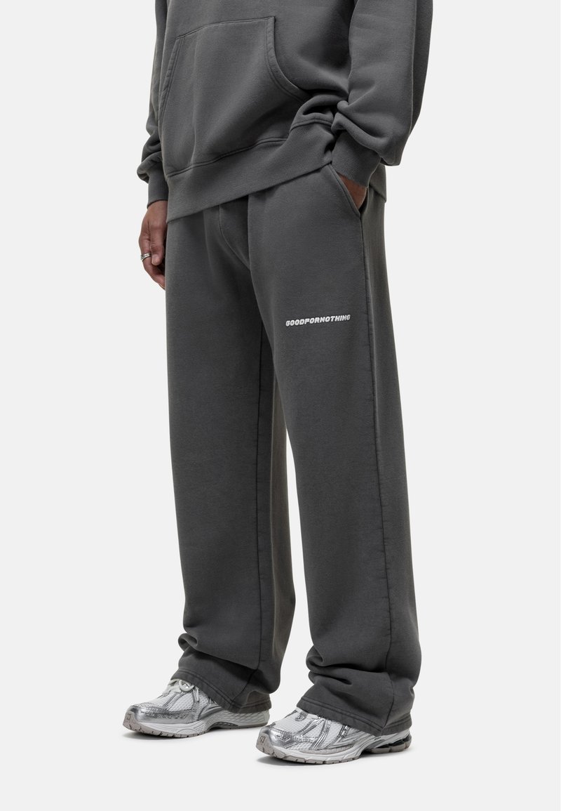 Grijze sweatshirt en sweatpants gemaakt van zachte stof, met een losse pasvorm, zijzakken en "GOODFORNOTHING" in het wit gedrukt op de broek.