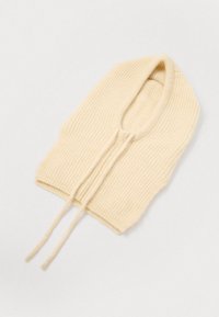 Collare beige lavorato a maglia con texture a coste, dotato di scollatura tonda e due stringhe. Design leggero e senza cuciture.
