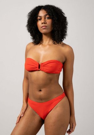 Röd bikiniuppsättning med en bandeau-top med snurrad detalj fram och matchande lågriskade bottnar. Slät tyg med matt finish.