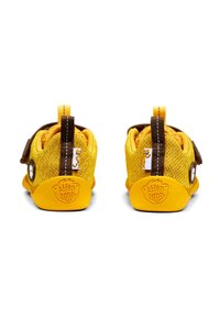 Scarpe in tessuto giallo con upper in rete testurizzata, dettagli marroni e suola in gomma. Presentano un logo sul tallone e una cinghia sicura.