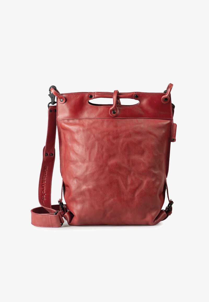 Red leather tote bag with a smooth texture, adjustable strap, and two top handles. Features metal hardware and a minimalist design.