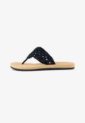 Juoda austinė šlepetė su tekstūruota diržele, smėlio spalvos padu ir juoda guminė padais. Minimalistinis dizainas su atviromis pirštų dalimis.