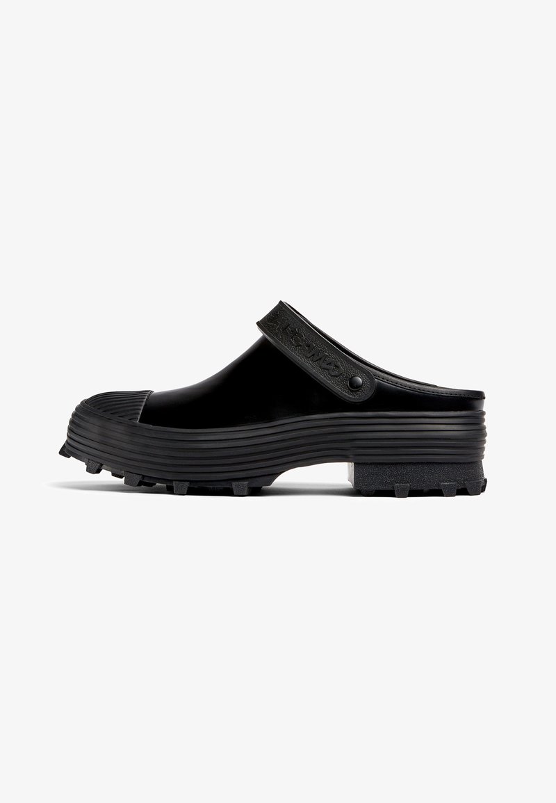 Black rubber clogs with a ridged sole and textured strap. Features a slightly raised toe cap and a durable, waterproof design.